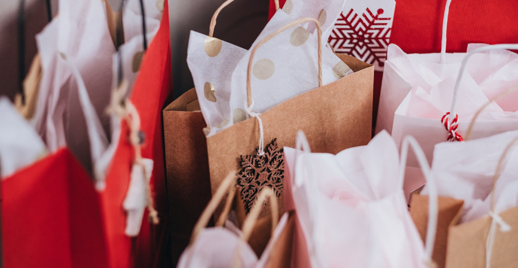 Sustainable Christmas gifts - image of brown and red paper bags with paper gift wrapping in Christmas designs.