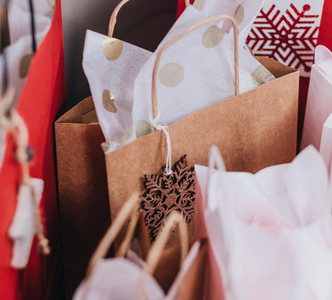 Sustainable Christmas gifts - image of brown and red paper bags with paper gift wrapping in Christmas designs.