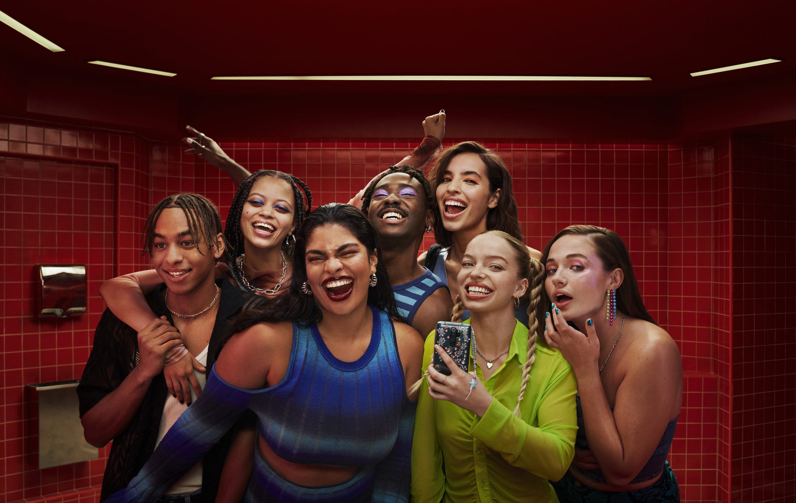 A group of happy young people smiling into a mirror